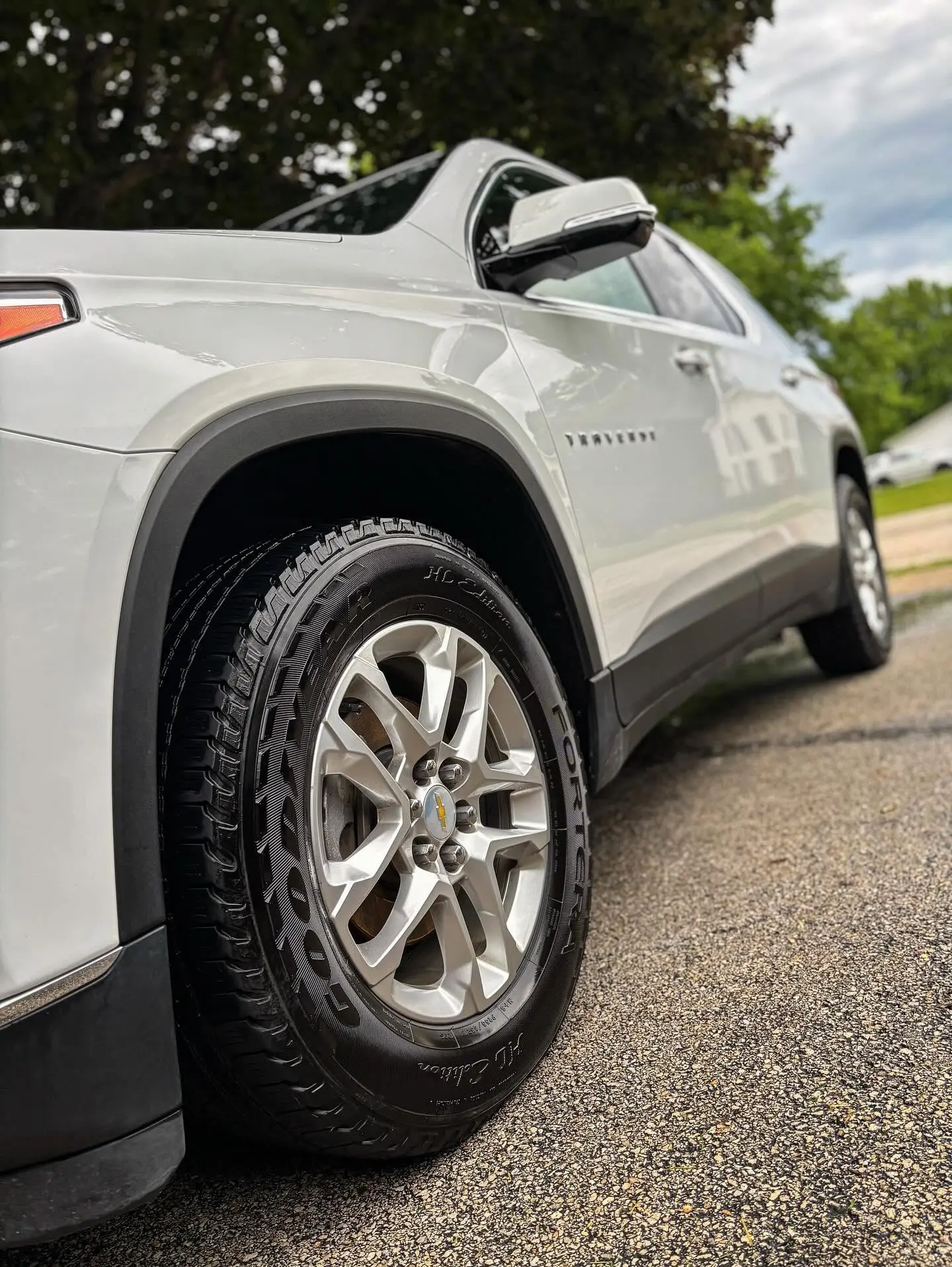 White Chevrolet Traverse with a polished wheel and glossy paint close up